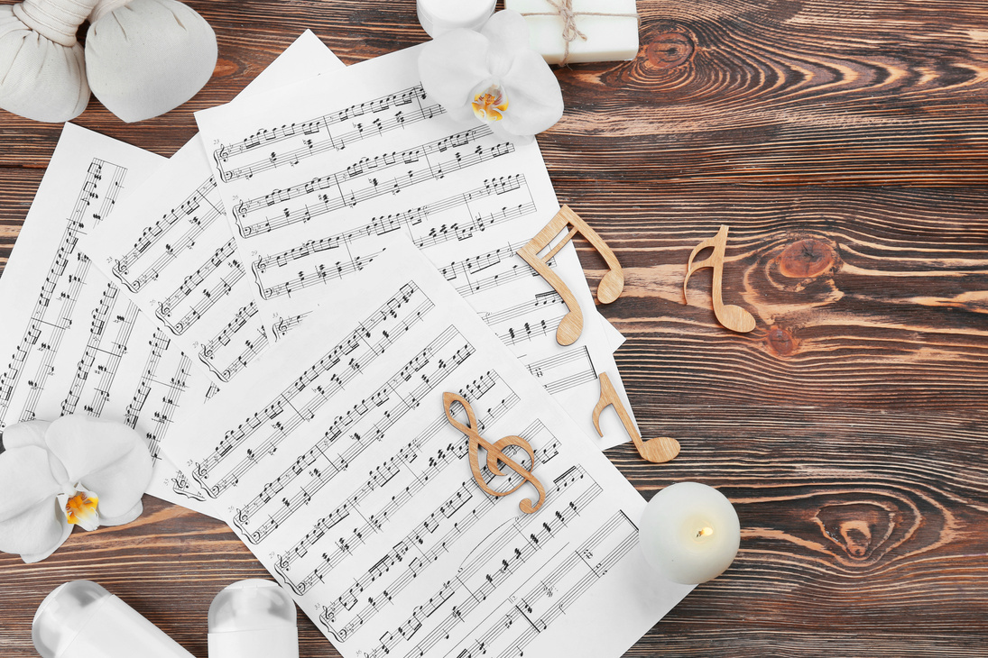 Music Sheets and Spa Supplies on Wooden Background